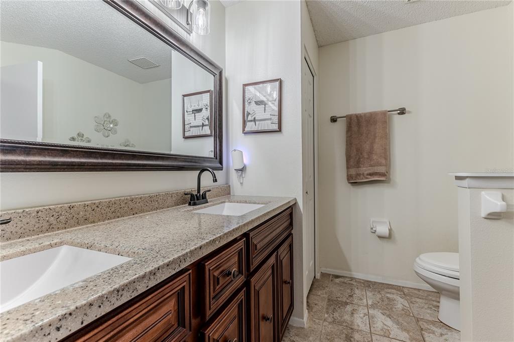 7443 Willowbrook Drive Spring Hill, FL 34606 - Photo 27 of 54 a bathroom with a granite countertop sink and a toilet