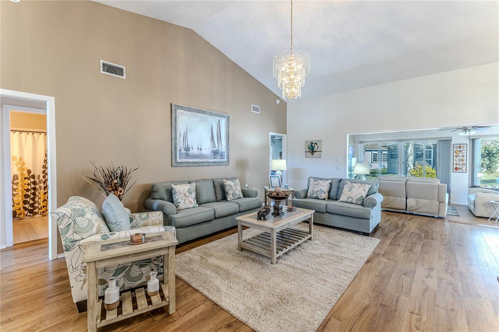 7443 Willowbrook Drive Spring Hill, FL 34606 - Photo 9 of 54 a living room with furniture and a chandelier