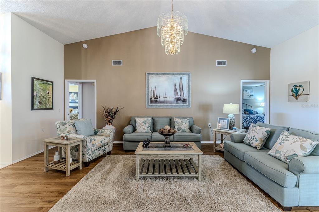 7443 Willowbrook Drive Spring Hill, FL 34606 - Photo 10 of 54 a living room with furniture chandelier and a table