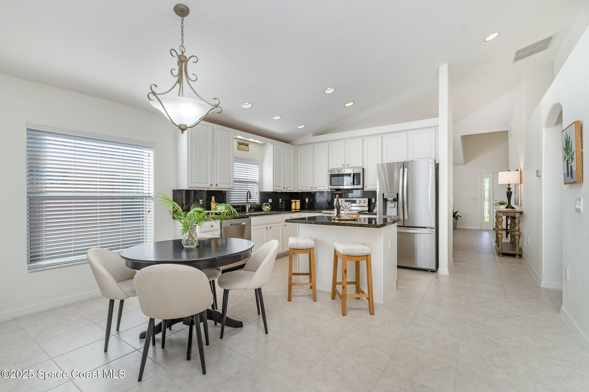 3053 Galindo Circle Melbourne, FL 32940 - Photo 11 of 83 a kitchen with a dining table chairs stainless steel appliances and windows