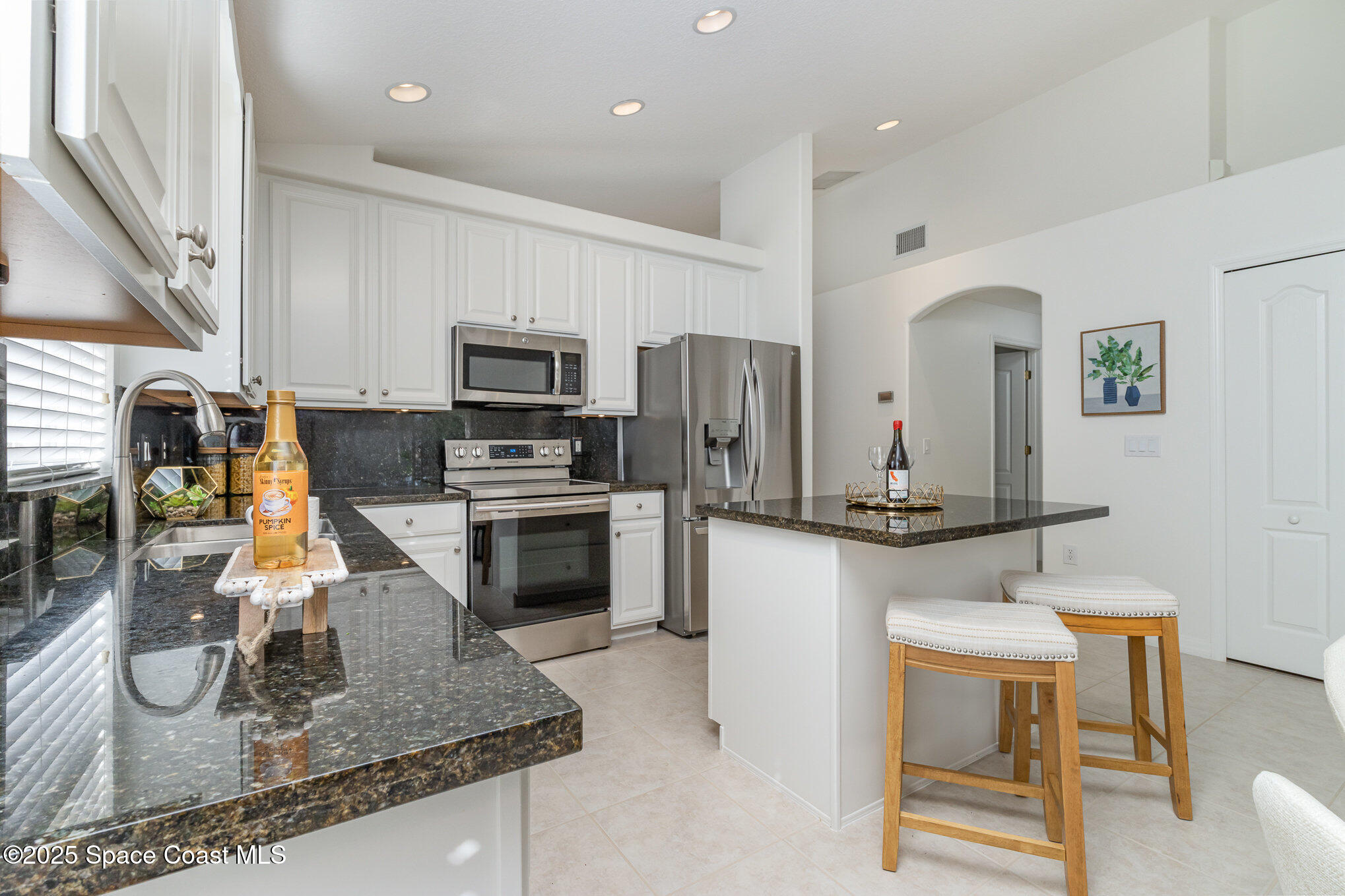 3053 Galindo Circle Melbourne, FL 32940 - Photo 16 of 83 a kitchen with stainless steel appliances granite countertop a sink refrigerator and cabinets