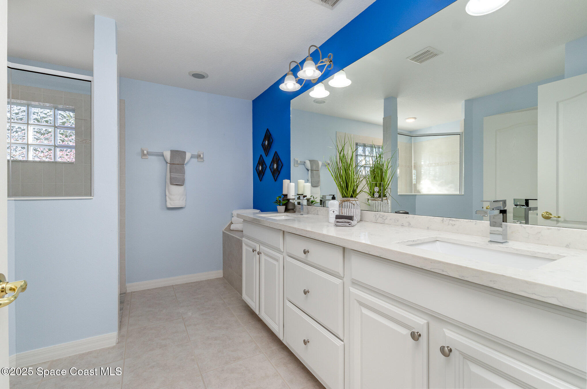 3053 Galindo Circle Melbourne, FL 32940 - Photo 23 of 83 a bathroom with a double vanity sink and a mirror