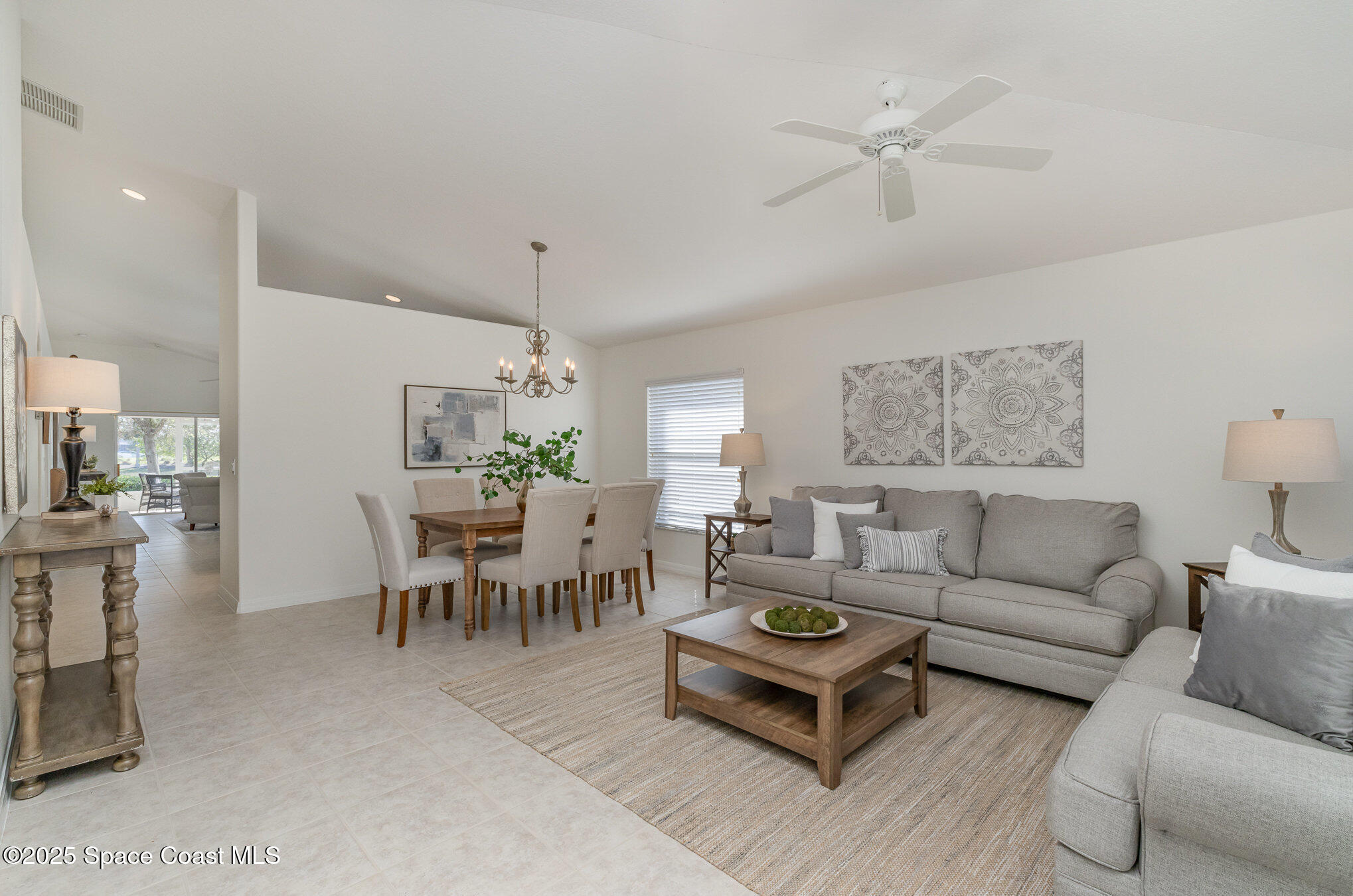 3053 Galindo Circle Melbourne, FL 32940 - Photo 6 of 83 a living room with furniture a chandelier and a dining table