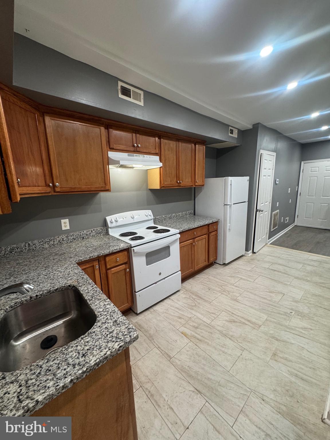 1108 North Bond Street, Unit 1 Baltimore, MD 21213 - Photo 12 of 20 a kitchen with stainless steel appliances granite countertop a sink stove and refrigerator