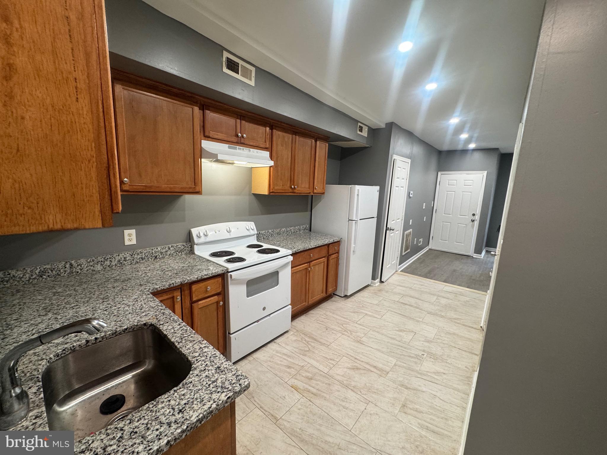 1108 North Bond Street, Unit 1 Baltimore, MD 21213 - Photo 13 of 20 a kitchen with stainless steel appliances granite countertop a sink a stove and a refrigerator