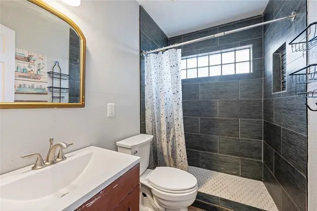 a bathroom with a sink a toilet and shower