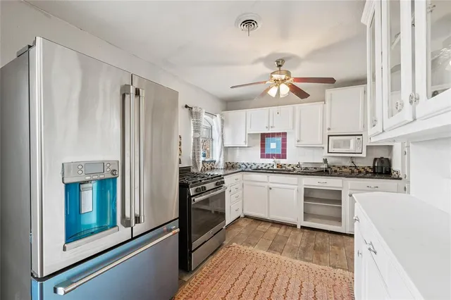 a kitchen with stainless steel appliances a stove a refrigerator and a sink