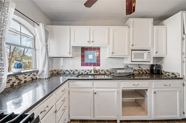 a kitchen with stainless steel appliances granite countertop a sink stove and cabinets