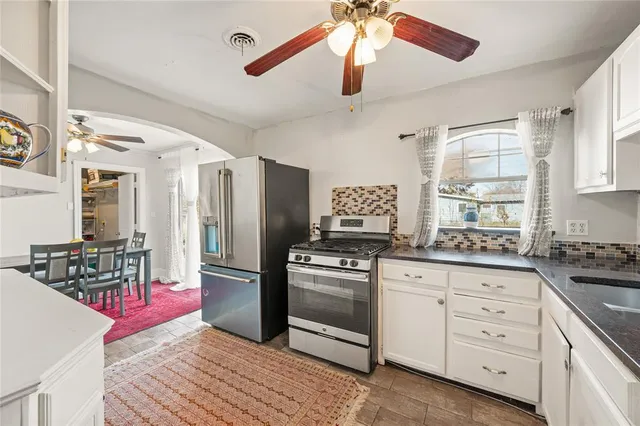 a kitchen with white cabinets and stainless steel appliances