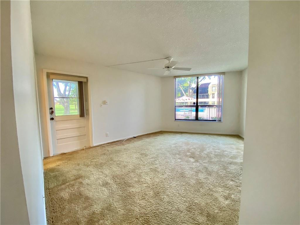 7650 West McNab Road, Unit 108 Tamarac, FL 33321 - Photo 2 of 18 an empty room with windows and cabinet