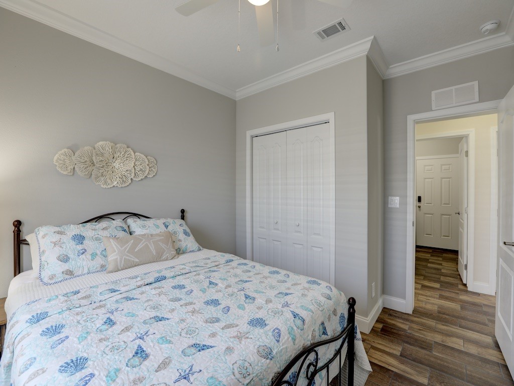 1011 Barefoot Circle Barefoot Bay, FL 32976 - Photo 20 of 31 a bedroom with a bed and wooden floor