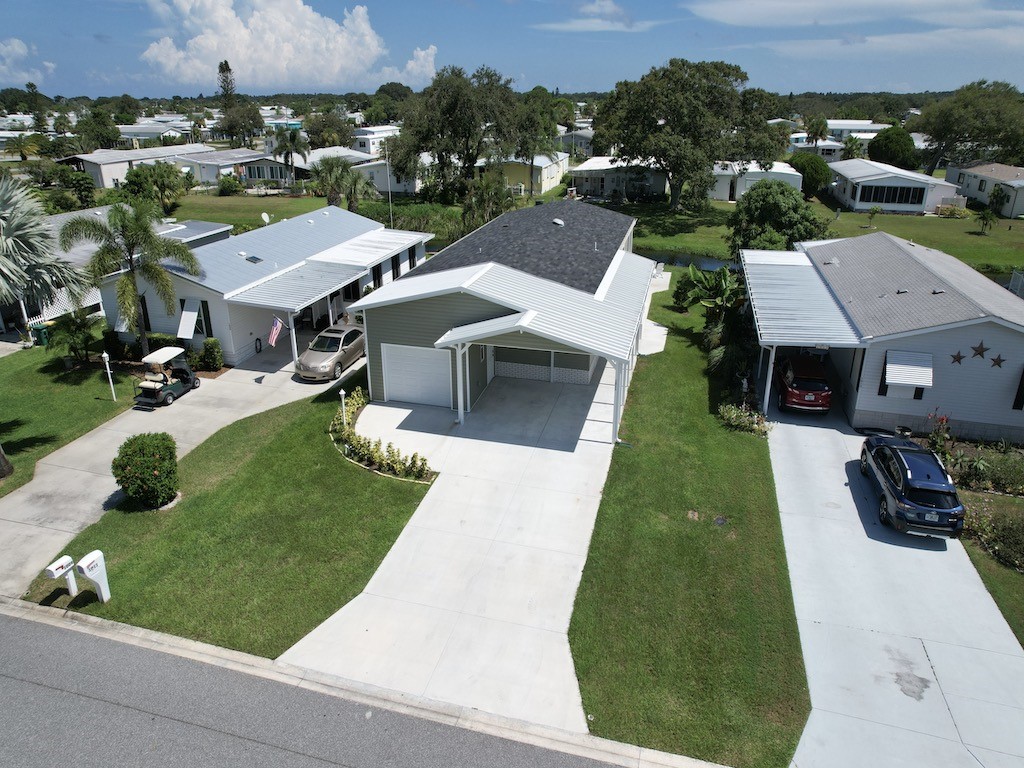 1011 Barefoot Circle Barefoot Bay, FL 32976 - Photo 2 of 31 an aerial view of a house with a garden and trees