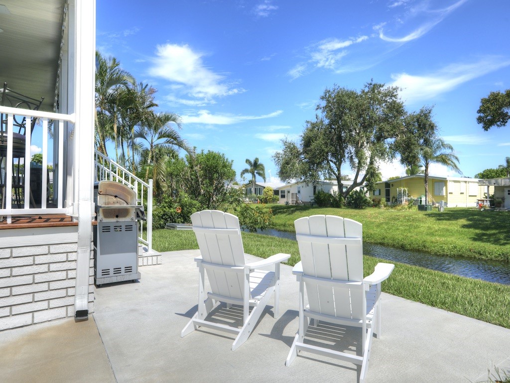 1011 Barefoot Circle Barefoot Bay, FL 32976 - Photo 24 of 31 a view of a chairs and table in backyard of the house
