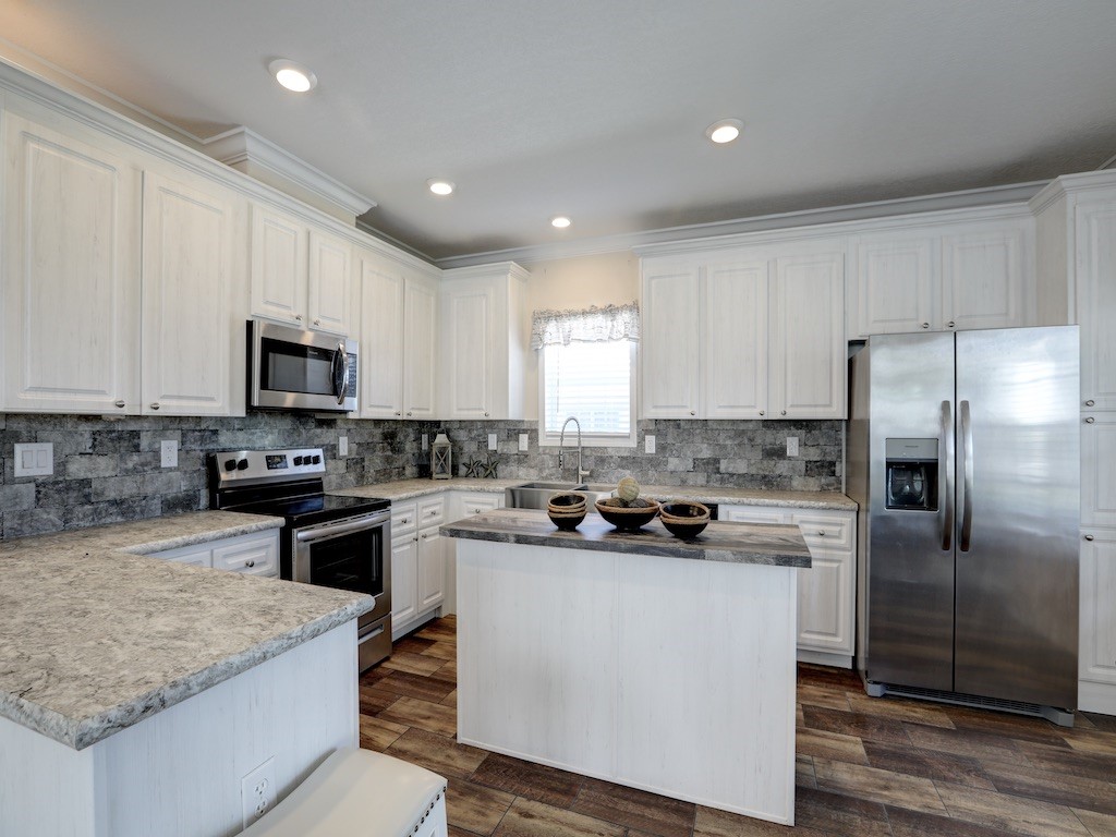 1011 Barefoot Circle Barefoot Bay, FL 32976 - Photo 10 of 31 a kitchen with a stove a sink a refrigerator a microwave and cabinets
