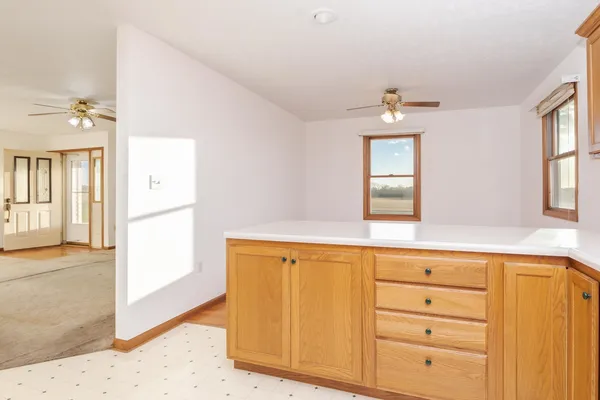 an empty room with a ceiling fan and a window