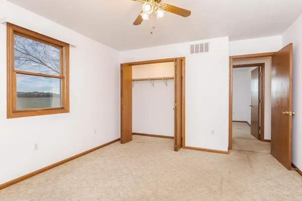 an empty room with closet and windows