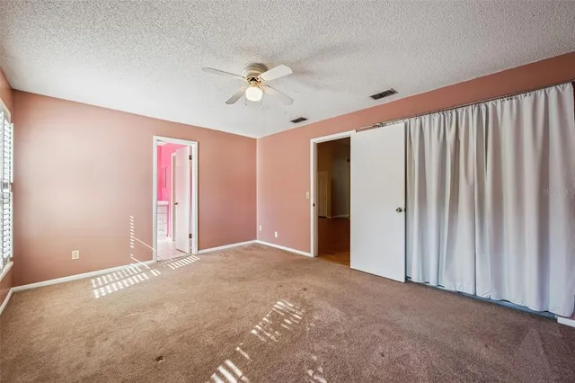 a view of a livingroom with a ceiling fan and window