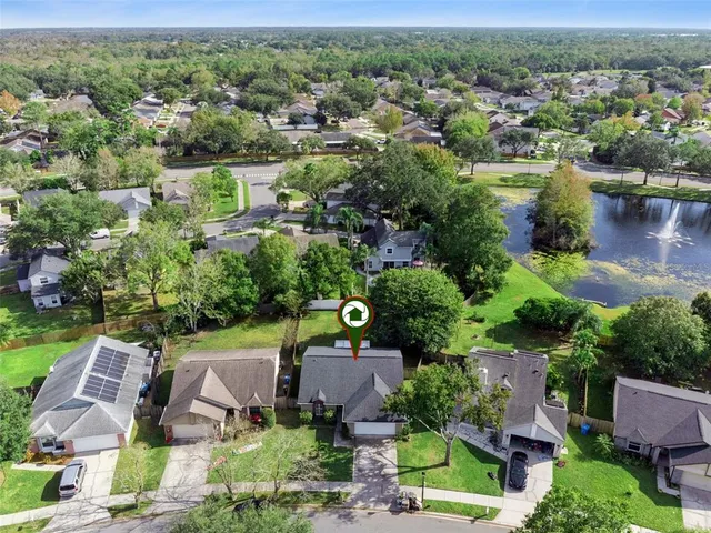 an aerial view of a house with a garden and lake view