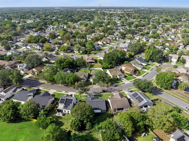 an aerial view of residential houses with outdoor space and trees