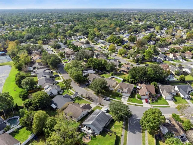 an aerial view of residential houses with outdoor space and trees