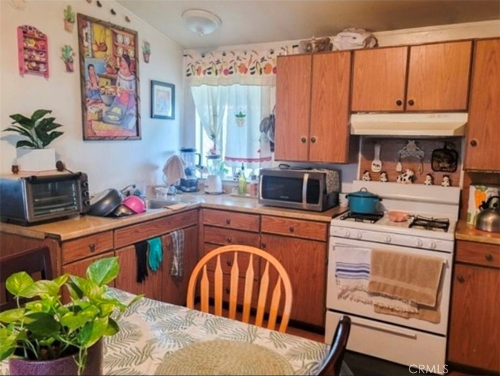 2500 North State Highway 59, Unit 278 Merced, CA 95348 - Photo 11 of 25 a kitchen with stainless steel appliances a stove a sink and a dining table