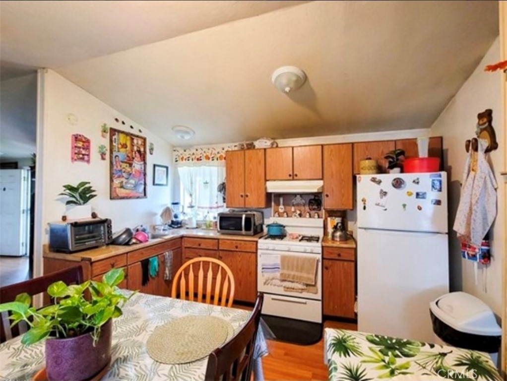 2500 North State Highway 59, Unit 278 Merced, CA 95348 - Photo 16 of 25 a kitchen with a refrigerator a stove a sink dishwasher and a dining table with garden view