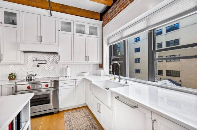 a kitchen with stainless steel appliances granite countertop a sink and cabinets with wooden floor