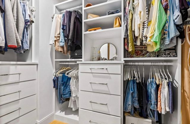 a view of walk in closet with clothes and shoes