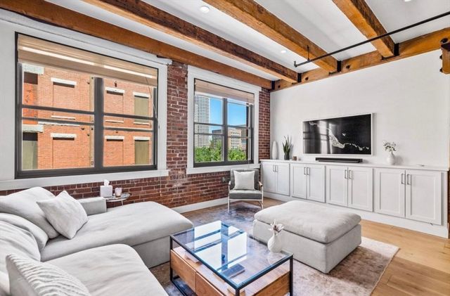a living room with furniture a flat screen tv and a large window