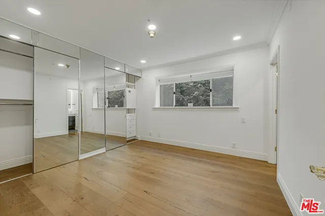 a view of empty room with wooden floor and window