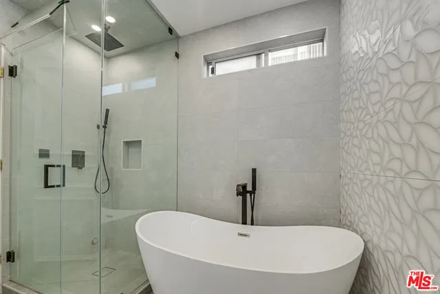 a white bath tub sitting next to a shower