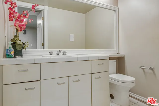 a bathroom with a sink vanity mirror and toilet