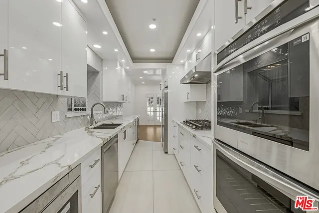 a kitchen with stainless steel appliances granite countertop a sink and cabinets