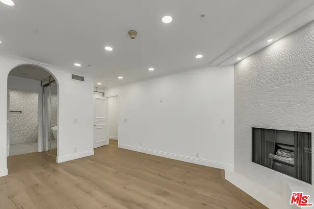 a view of a hallway with wooden floor and a fireplace