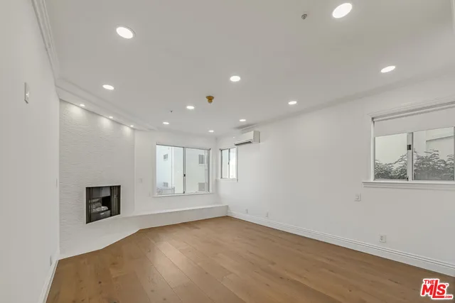 an empty room with wooden floor and fireplace
