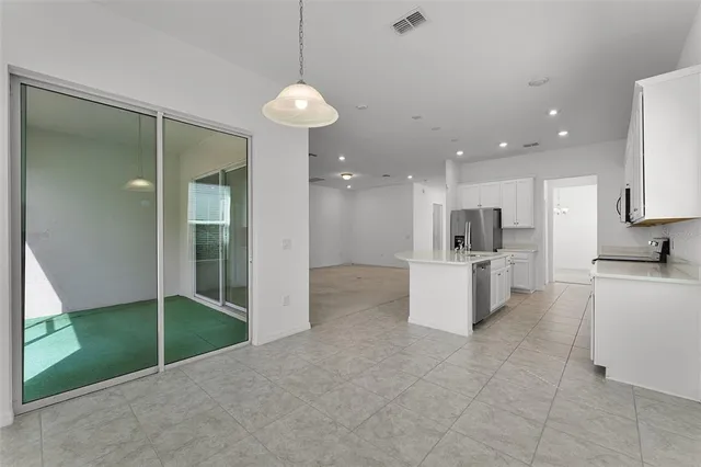 a view of kitchen with kitchen island stainless steel appliances counter space and living room view