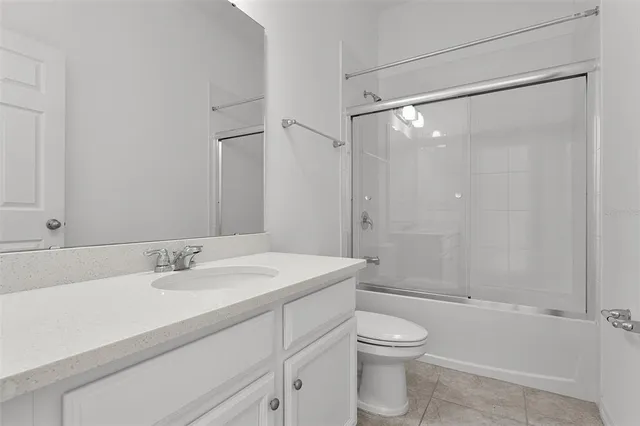 a bathroom with a sink a mirror toilet and shower