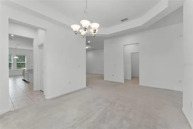 a view of an empty room with chandelier