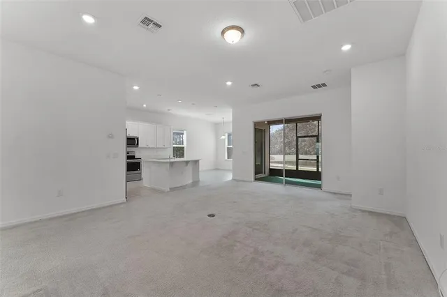 a view of an empty room with a kitchen