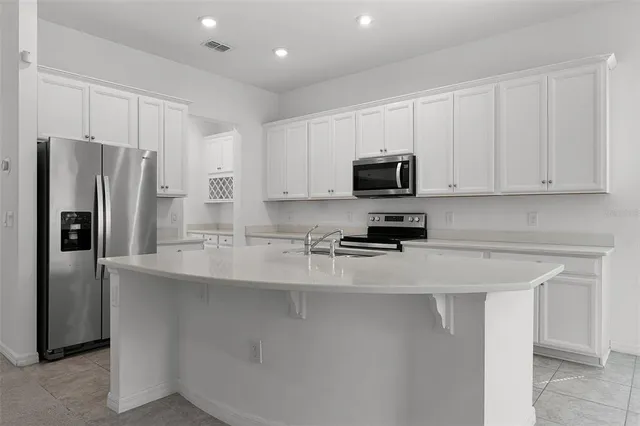 a kitchen with stainless steel appliances a refrigerator a stove a microwave and a sink