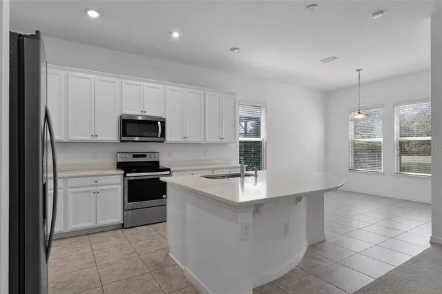 a large kitchen with stainless steel appliances granite countertop a stove a sink and a refrigerator