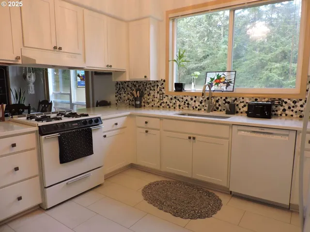 a kitchen with white cabinets and white appliances