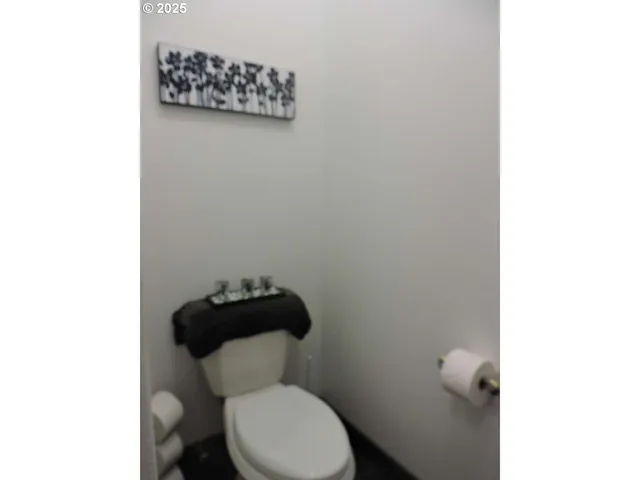a white toilet sitting next to a white wall
