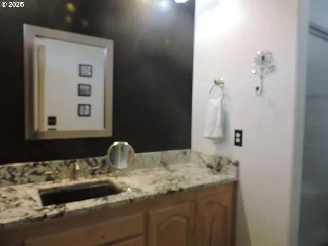 a bathroom with a granite countertop sink and a mirror