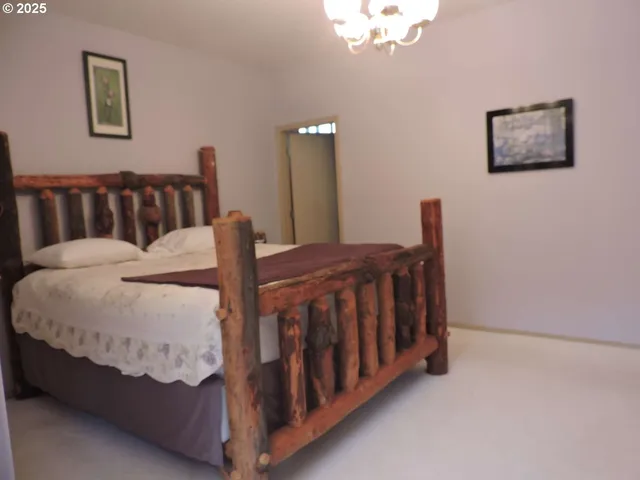 a bed sitting in a bedroom next to a lamp