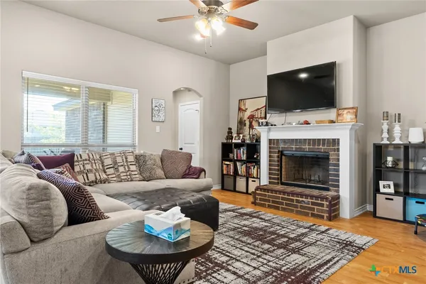 a living room with furniture a flat screen tv and a fireplace