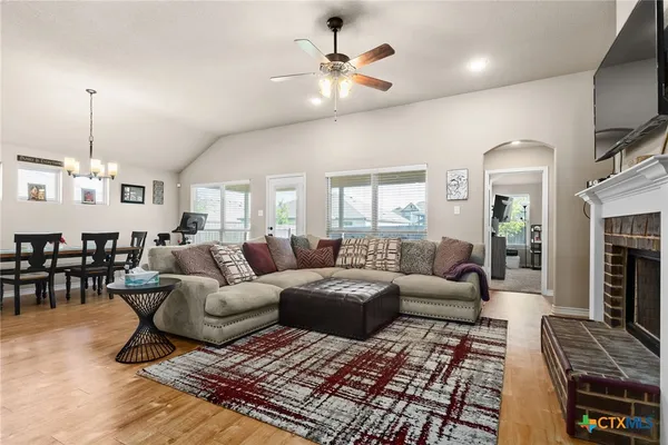 a living room with furniture a chandelier and a fireplace