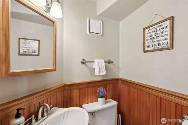 a bathroom with a toilet a sink and mirror