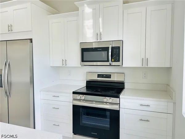 a kitchen with cabinets stainless steel appliances and a counter space
