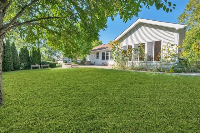 a front view of a house with a garden and trees